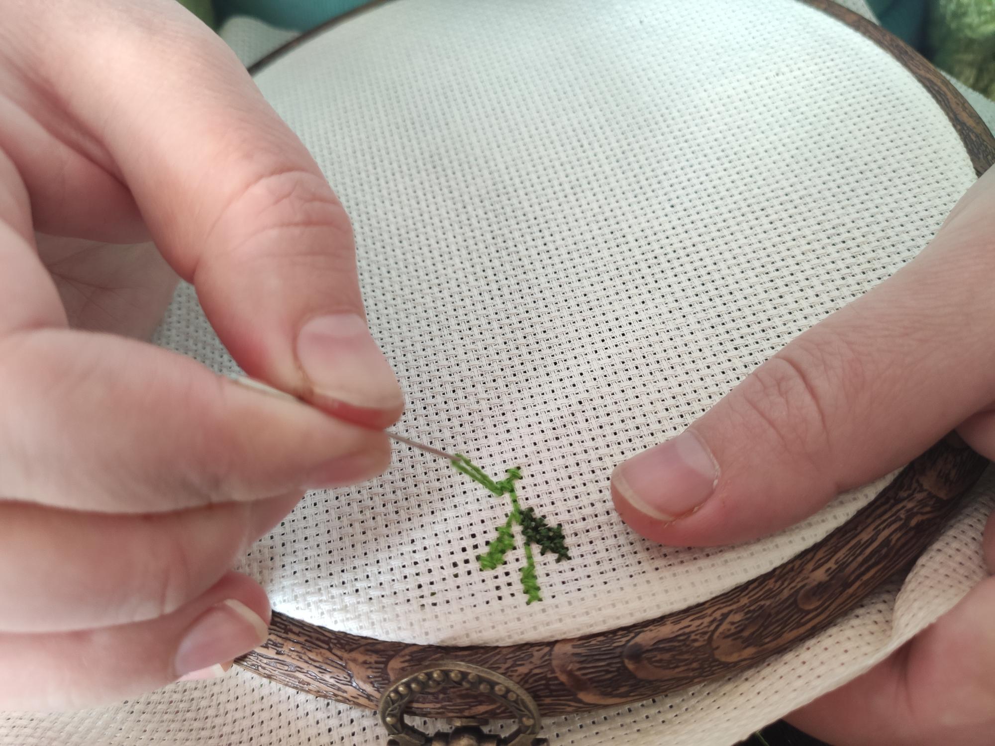 Close crop of embroidered seed stitch on cream fabric